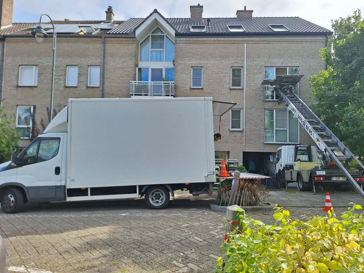 Camion avec lift devant un immeuble